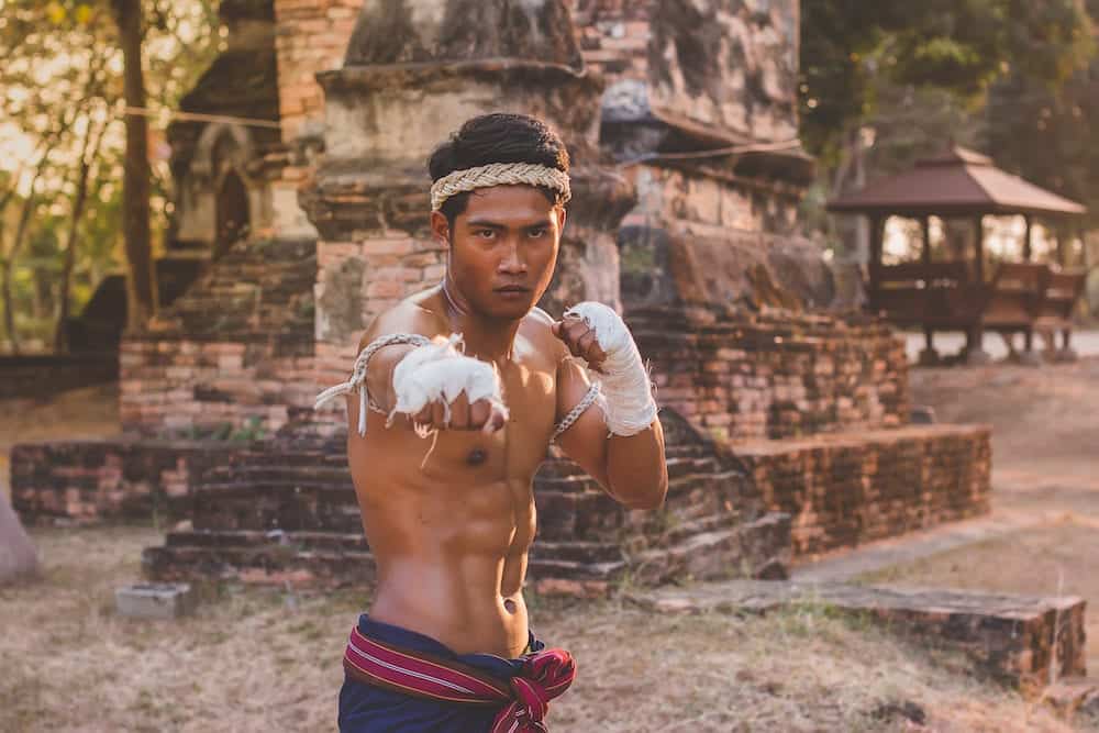 Ancient Muay Thai, Asian man exercising thai boxing,Ancient traditional Muay Thai or Thai boxing fighter putting bandage old style at Thailand.