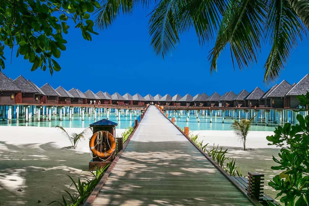 Beautiful tropical resort with wihte beach and turquoise water for relax on Olhuveli island, Maldives. White sand beach with a coral reef. Best beach for relaxation, sunbathing and snorkeling.