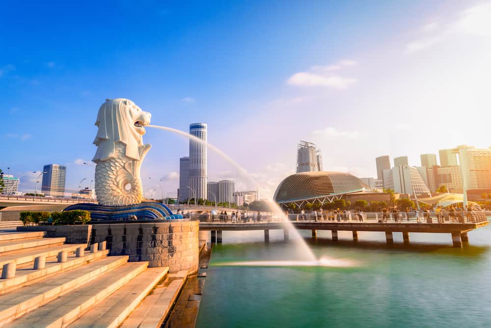 SINGAPORE-: Merlion statue fountain in Merlion Park and Singapore city skyline at sunrise. Merlion fountain is one of the most famous tourist attraction in Singapore.