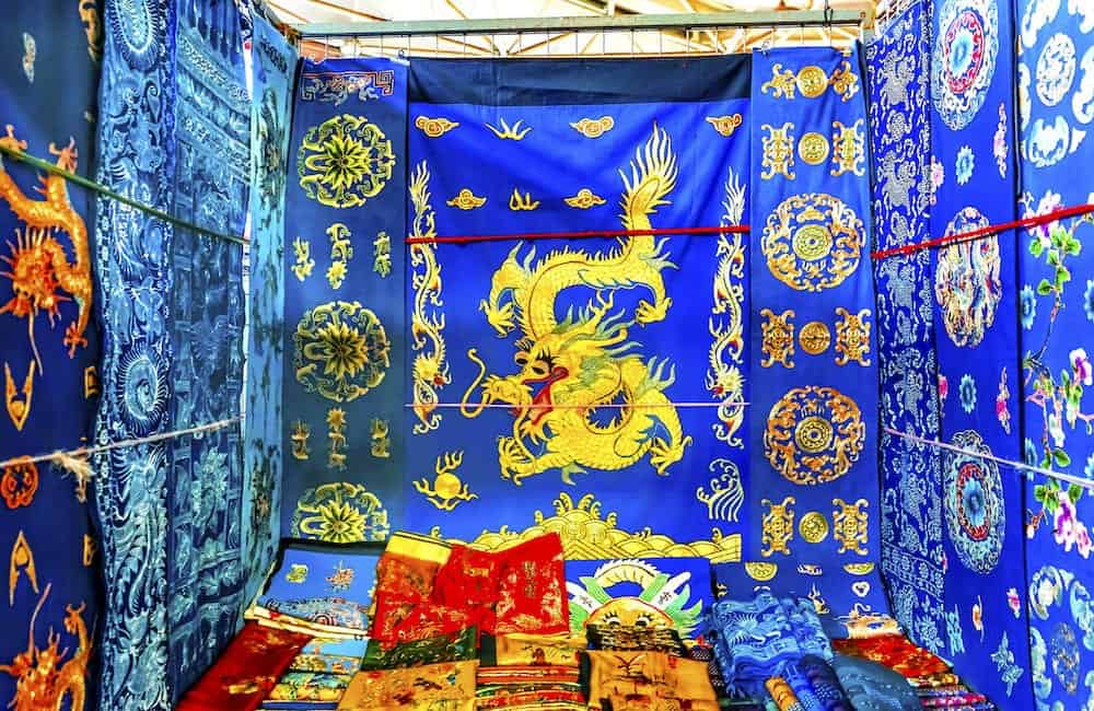 Blue Red Yellow Chinese Dragon Replica Silks Panjuan Flea Market Decorations Beijing China. Panjuan Flea Curio market has many fakes, replicas and copies of older Chinese products, many ancient.