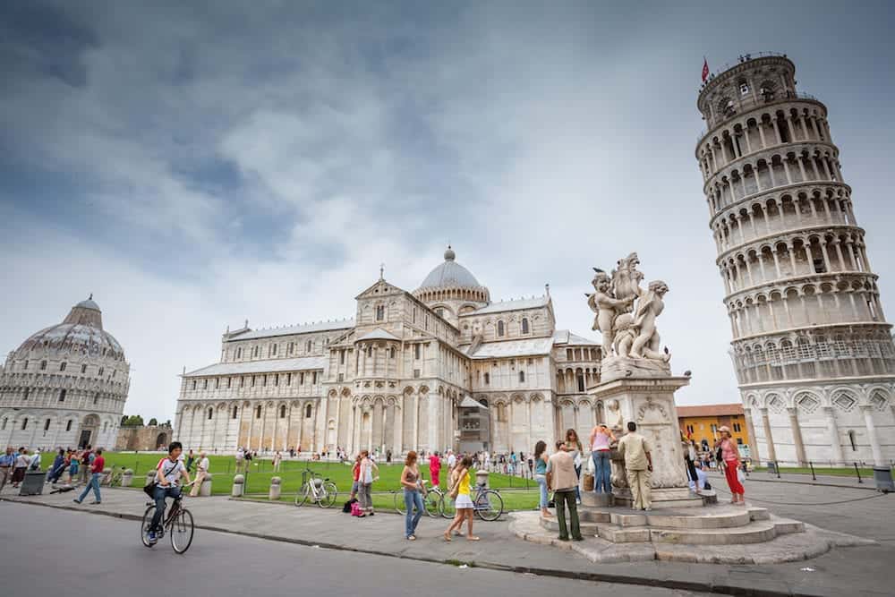 PISA, ITALY Tourist sightseeing Piazza del Duomo with Leaning Tower of Pisa, The Pisa Baptistery of St. John, Pisa Cathedral and The Fountain with Angels in Pisa, Italy.