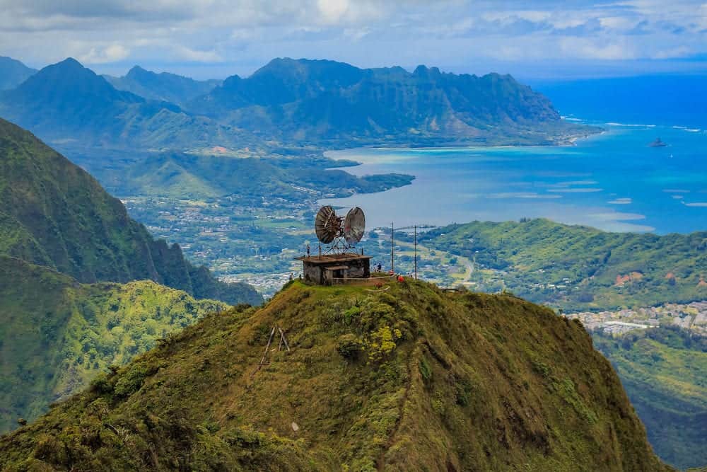 Aerial view of CCL Building bunker at the top of Stairway to Heaven or Haiku Stairs with mountains, coastline and 's Hat island in the background in Honolulu, Hawaii viewed from a helicopter