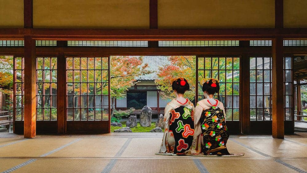 Japanese Geisha at Look at a Japanese Garden in Colorful Autumn at Kenninji Temple in Kyoto