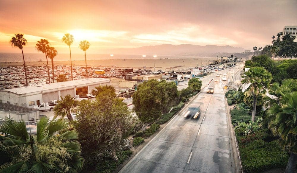 Aerial panoramic view of Ocean Ave freeway in Santa Monica beach at sunset - City streets of Los Angeles and California state surrounds - Warm twilight color filter tones with dark vignetting