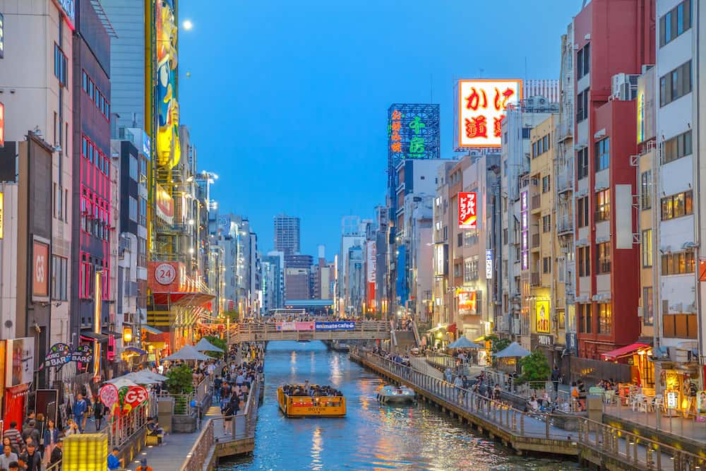 Osaka, Japan - Dotonbori Canal cruise at blue hour in Namba District, a popular shopping and entertainment district. The Dotonbori Canal is a famous sightseeing spot in Osaka city.