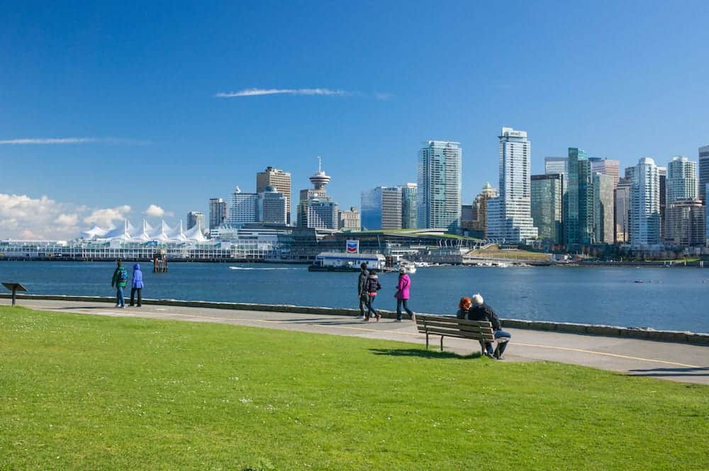 VANCOUVER CANADA - Unidentified people walk on seawall in Stanley Park. Seawall is 8.8-kilometre paved route that loops around the park. It's one of the park biggest attractions for sightseers and recreation enthusiasts.