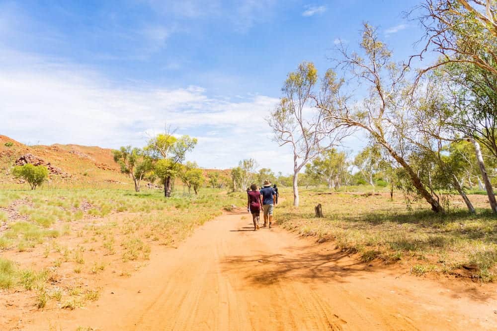 People hiking on a hot day along a track in the Pilbara region in North Western Australia, Australia.