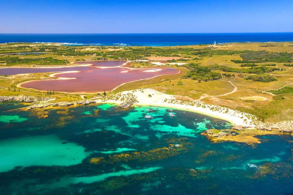 Aerial view of Pink lake and coastline of Rottnest Island in Australia. Scenic flight over famous tourist destination of Western Australia. Rottnest Island is located near Fremantle and Perth.