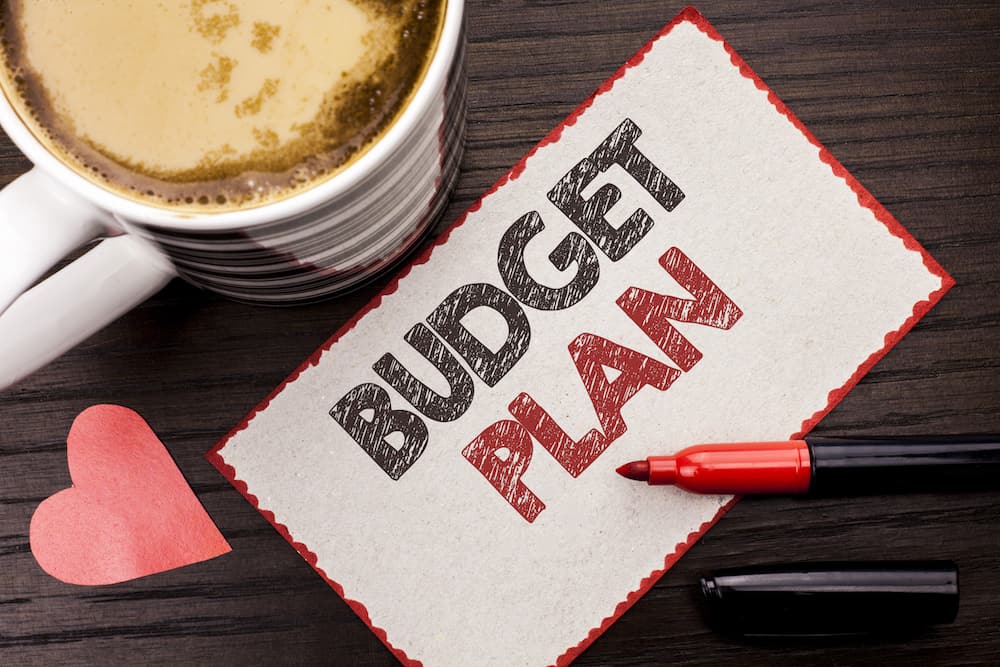 Text sign showing Budget Plan. Conceptual photo Accounting Strategy Budgeting Financial Revenue Economics written Sticky Note the wooden background Coffee Cup Heart Marker next to it.