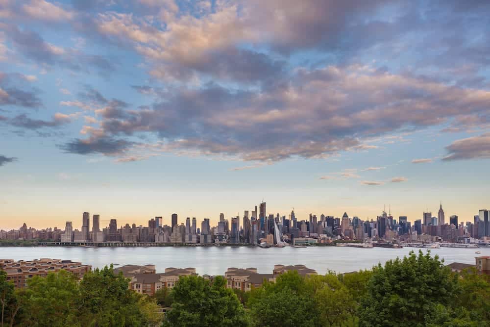 New York City midtown Manhattan sunset skyline panorama view from Boulevard East Old Glory Park over Hudson River.