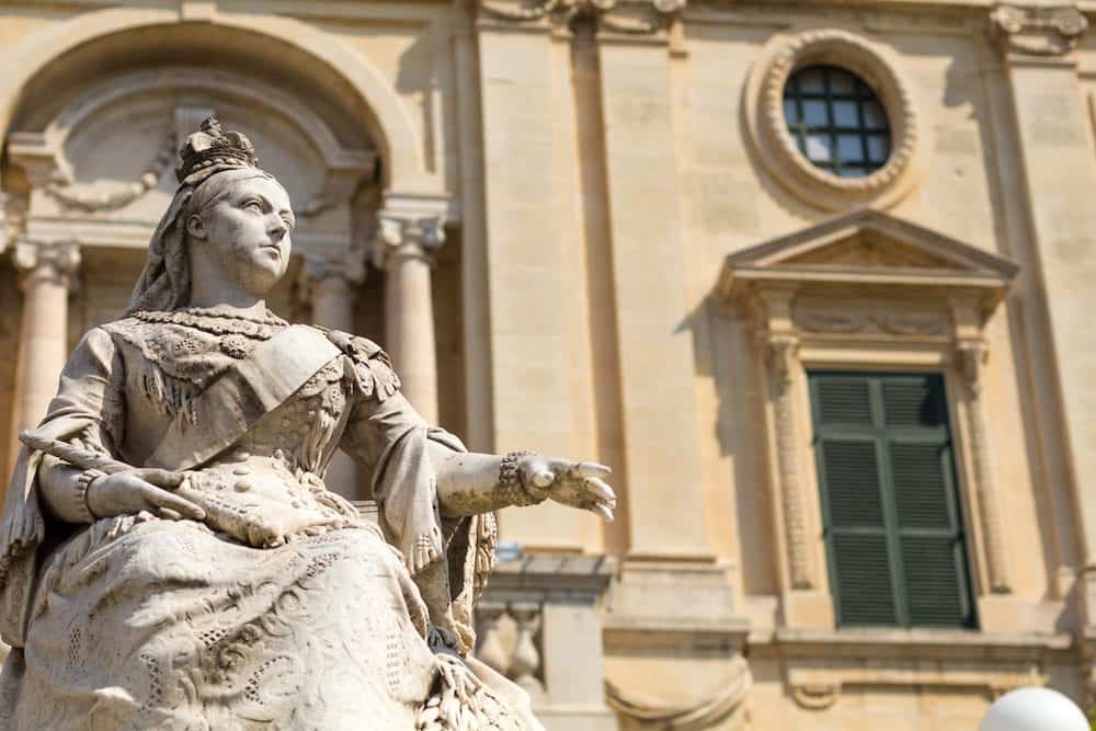 Statue of Queen Victoria Republic Square Valletta Malta Europe. With the limestone National Library of Malta in background