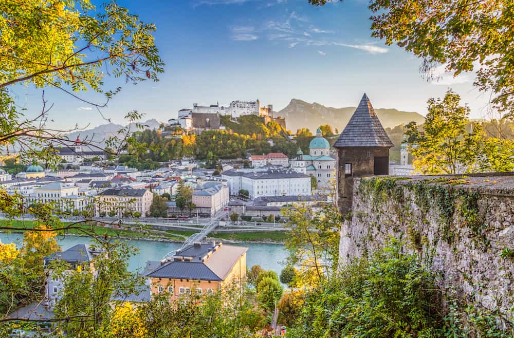 Aerial panoramic view of the historic city of Salzburg with famous Hohensalzburg Fortress and fortification tower in beautiful golden evening light at sunset in fall Salzburger Land Austria