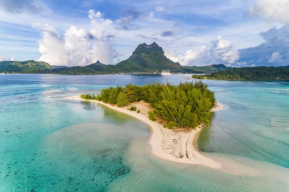 Bora Bora aerial view of luxury travel cruise ship vacation destination. Drone shot above motu paradise island r in lagoon and Mt Pahia, Mount Otemanu, Tahiti, French Polynesia, South Pacific Ocean.