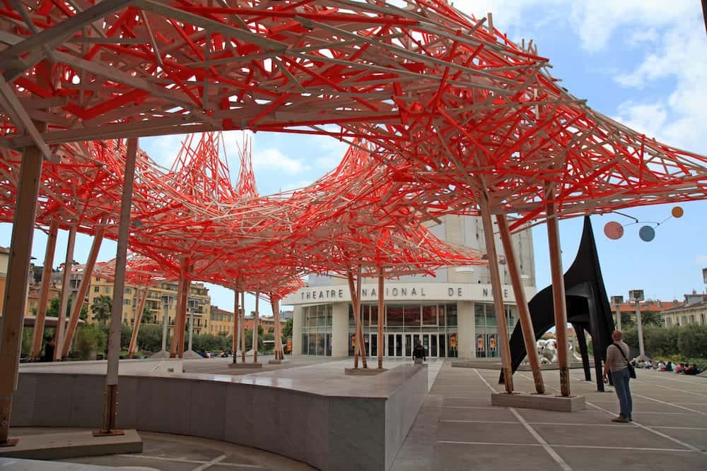 NICE, FRANCE - : Contemporary wooden and metal art installation named 'Hommage Alexander Calder' and view of the National Theater of Nice France. View from Museum of Modern and Contemporary Art (MAMAC)