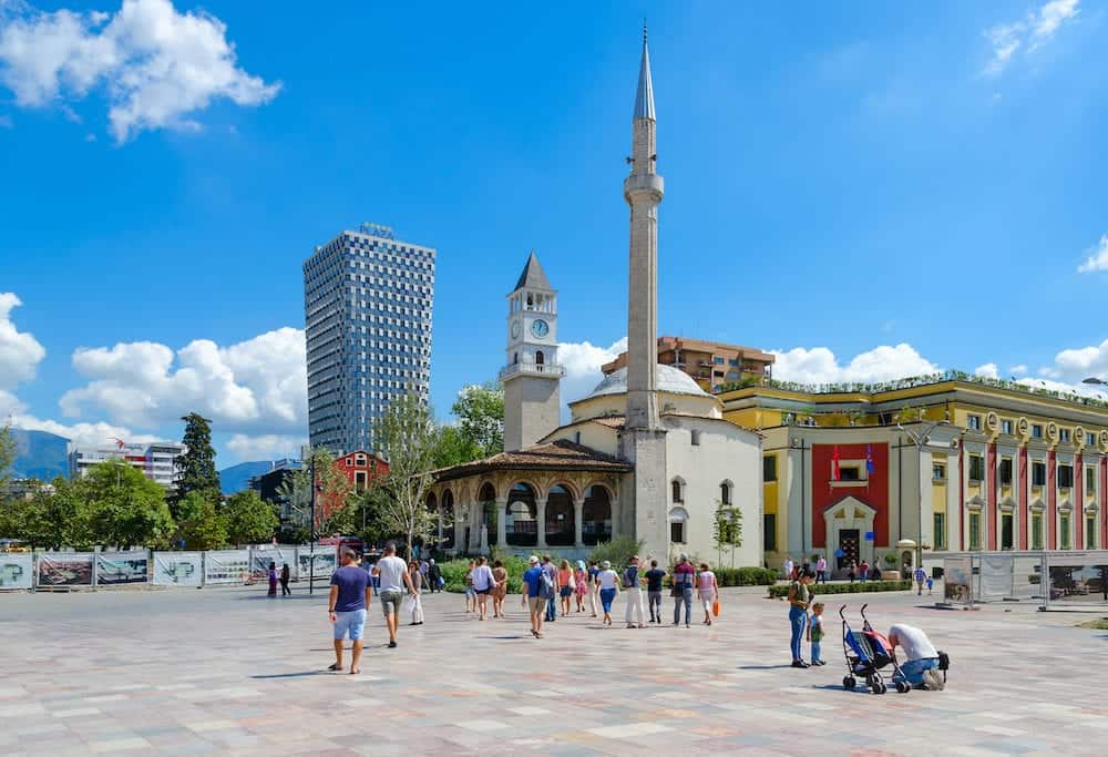 TIRANA ALBANIA - Group of unknown tourists on Skanderbeg Square. Efem Bay Mosque Clock Tower Plaza Hotel Tirana Albania