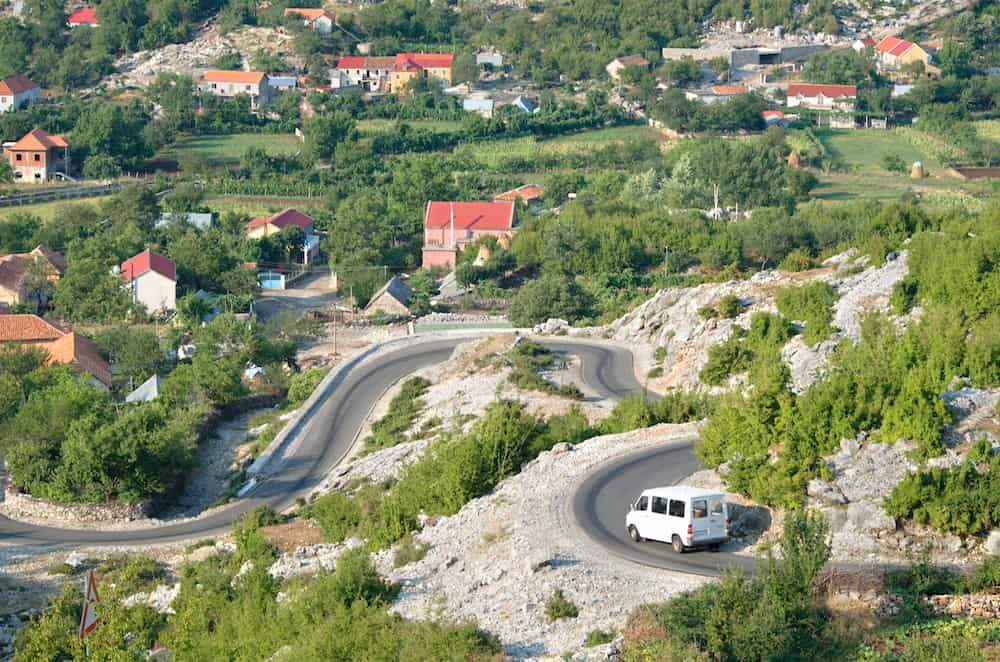 white minibus on the winding road from Razem to Shkoder, Albania