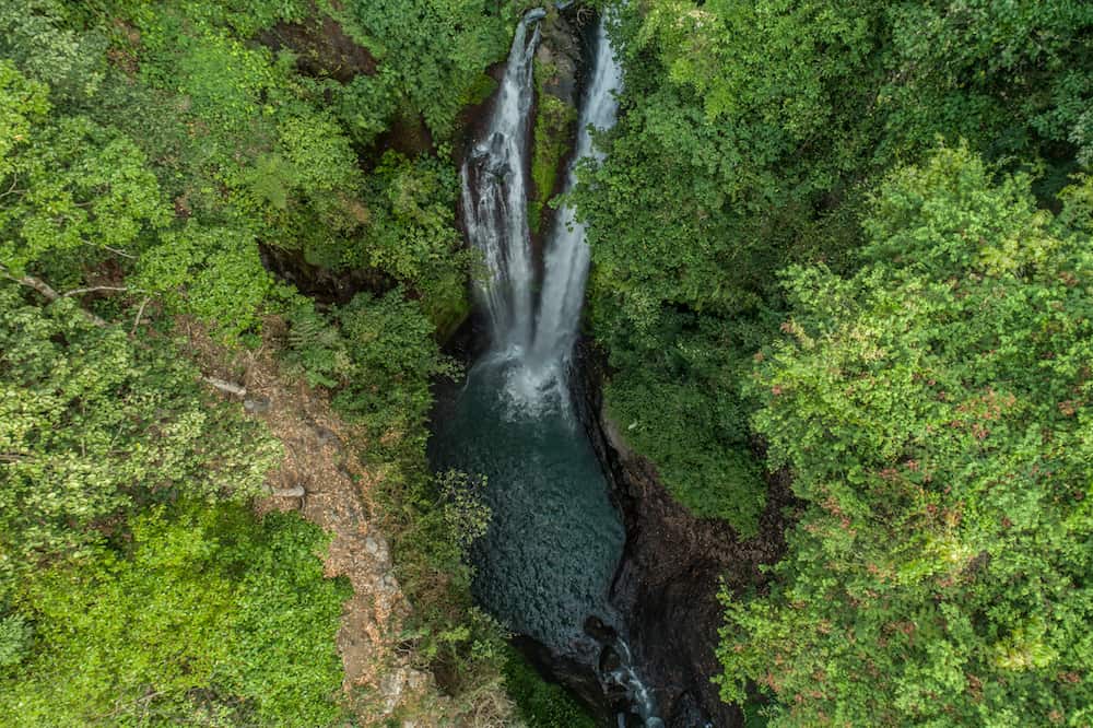 Aerial drone view of beautiful Aling Aling waterfall in nothern Bali, Indonesia
