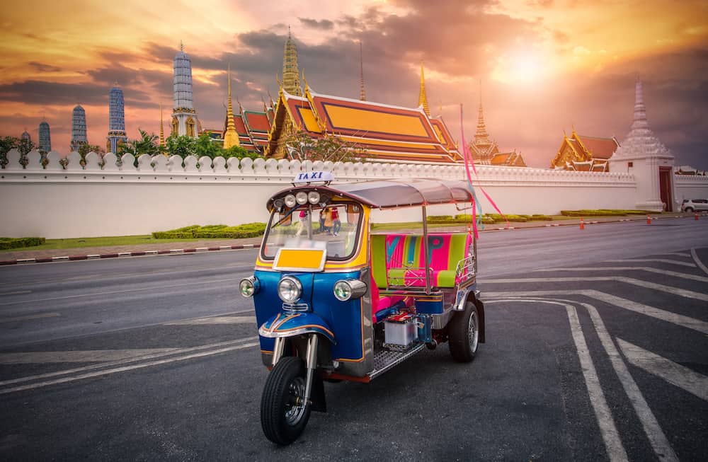 Tuk tuk on the background of Bangkok's Grand Palace Complex and Wat Phra Kaew, one of Bangkok's tourist attractions, Bangkok, Thailand