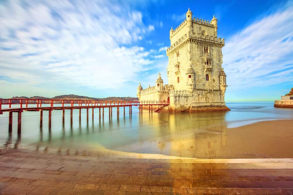 Scenic Belem Tower and wooden bridge miroring with low tides on Tagus River. Torre de Belem is Unesco Heritage and icon of Lisbon and the most visited attraction in Lisbon, Belem District, Portugal.