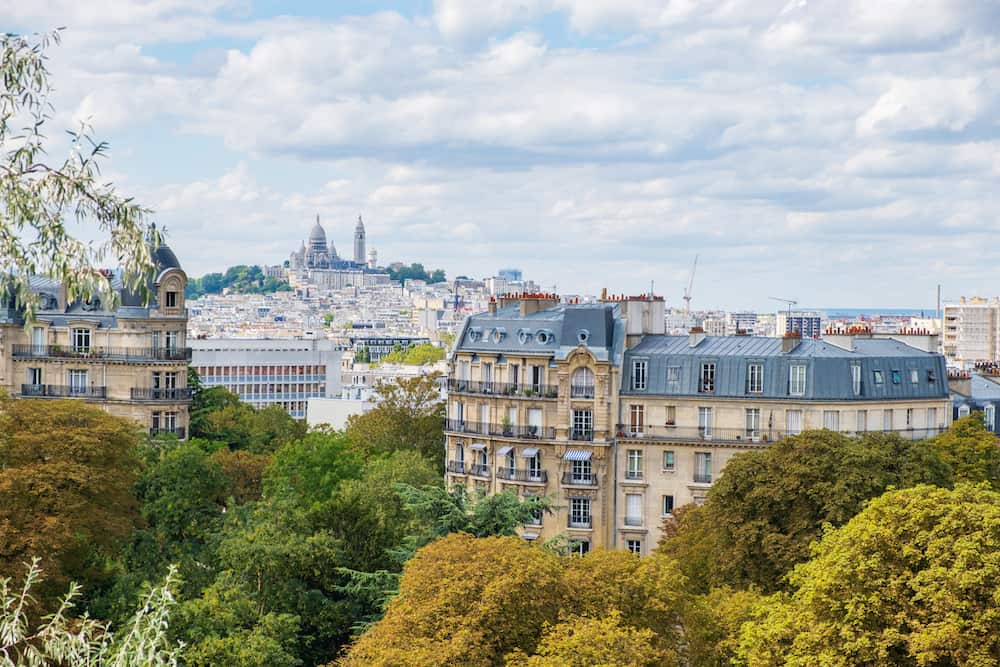 Paris skyline with Montmartre hill and Sacre Coeur Basilica viewed from Buttes-Chaumont Park.