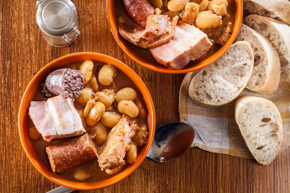 Bowl with fabada asturiana. Traditional spanish bean stew with chorizo, bacon and other meats