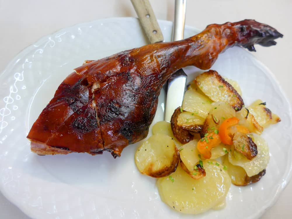 Typical roast suckling pig leg. Traditional spanish Castilla y Leon recipe. Cochinillo asado