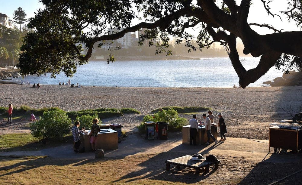 Shelly Beach and Cabbage Tree Bay Aquatic Reserve at Manly with sand and Tasman Sea. People relaxing on sandy Shelly beach at Manly.