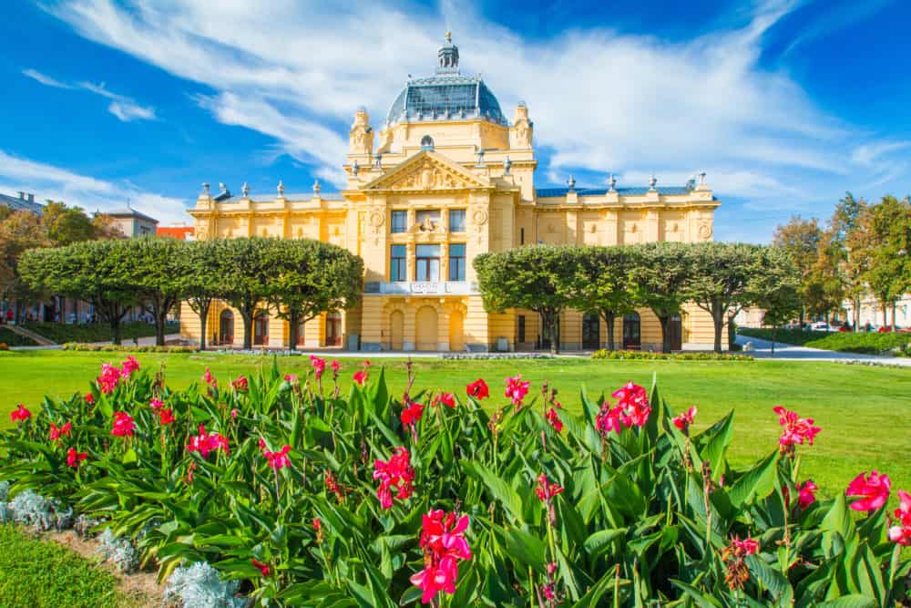 Zagreb, Croatia, art pavilion and beautiful flowers in park in summer day, colorful 19 century architecture