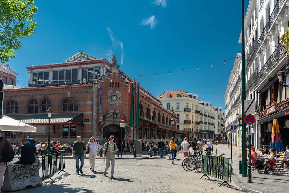 Brussels, Belgium - : People near the Halles Saint-Gery on a sunny day. In 1882, this was a covered market. Now it is well known for the many bars and restaurants in the area.