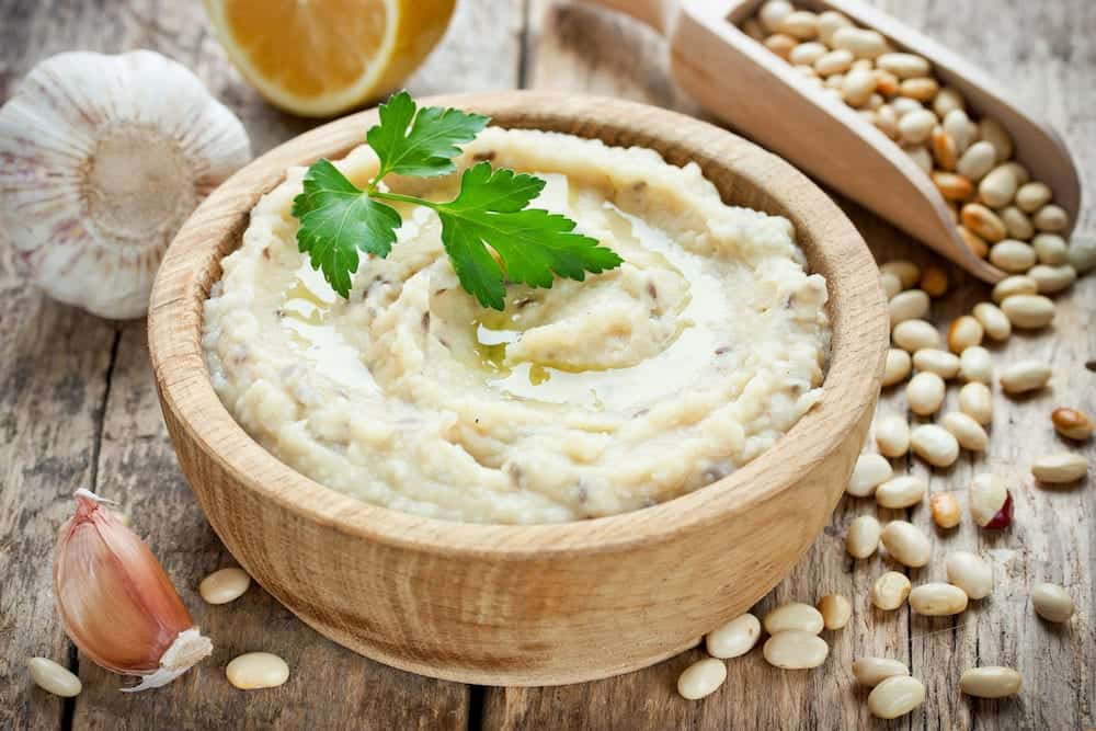 White beans hummus with lemon garlic and flax in wooden bowl traditional arabic cuisine