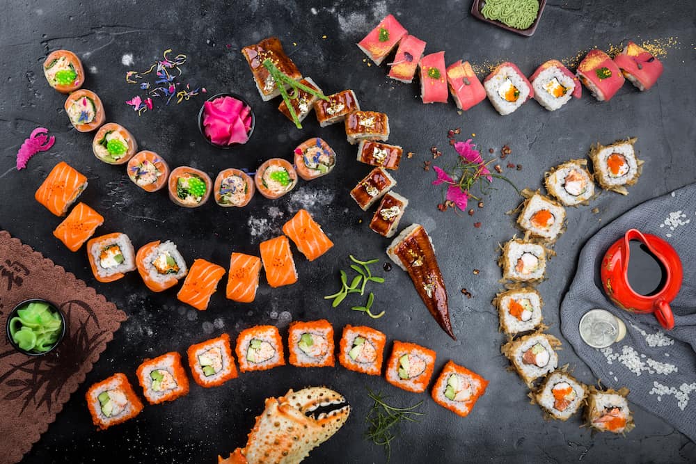 Sushi on a black background. Sushi rolls, nigiri, pickled ginger, wasabi, soy sauce. Sushi set on a table. Top view. Asian or Japanese food. Sushi restaurant concept