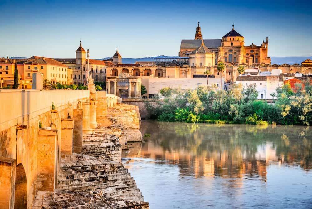 Cordoba Spain. Roman Bridge on Guadalquivir river and The Great Mosque (Mezquita Cathedral) at twilight in the city of Cordoba Andalusia.