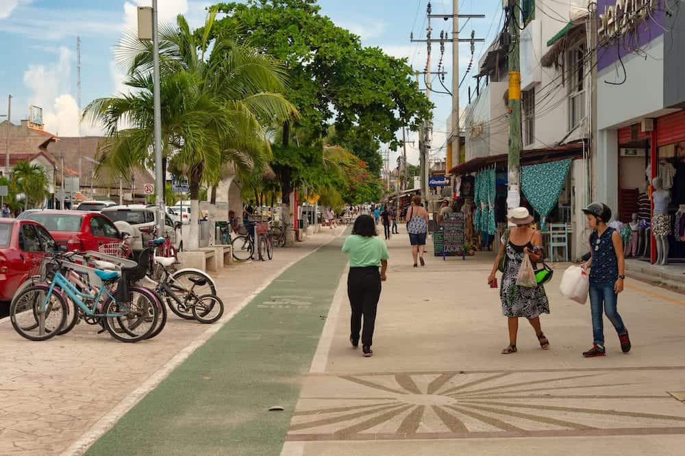 Tulum, Mexico - People walking on the sidewalk on Avenida Tulum.