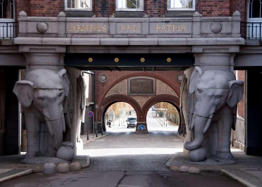 COPENHAGEN DENMARK - Monumental gate at Carlberg's brewery in Copenhagen features two giant statues of an elephant. The latin very patriotic message reads: let's work for our homeland.