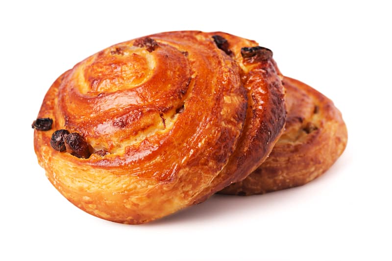 Freshly baked delicious sweet bun with raisins isolated white background