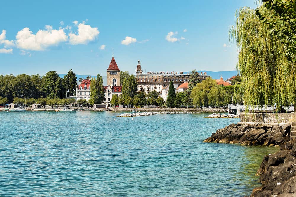 Lausanne, Switzerland - Chateau Ouchy at Lake Geneva promenade, Lausanne, Switzerland. People on the background