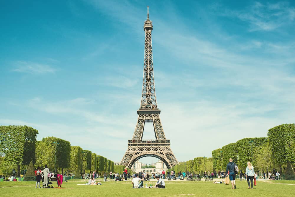 Paris France - Tourists chilling in park near Eiffel Tower Paris France. More than 15 million tourists visited the city of Paris.