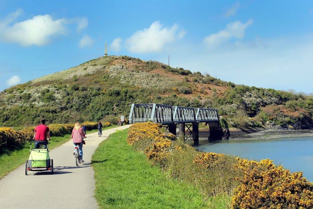 Camel Estuary Cornwall UK Cyclists approaching the disused iron railway bridge on the Camel Trail in Cornwall