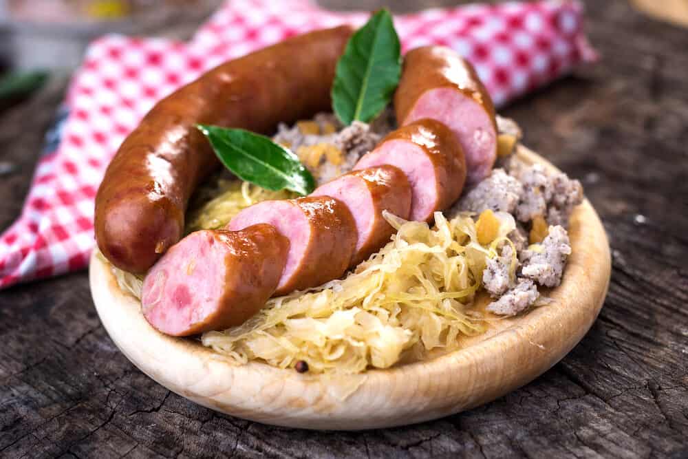 Sausages with sauerkraut and buckwheat mush on wooden background