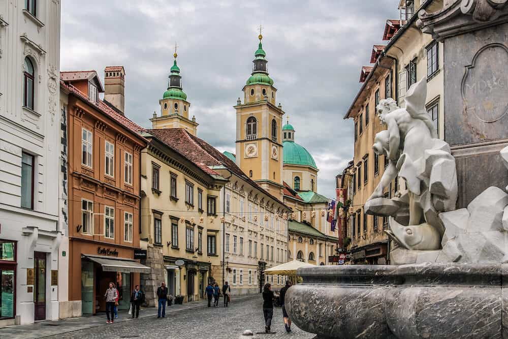 Ljubljana, Slovenia - . View from the Robba Fountain of an old street, houses and the St. Nicholas' Cathedral.