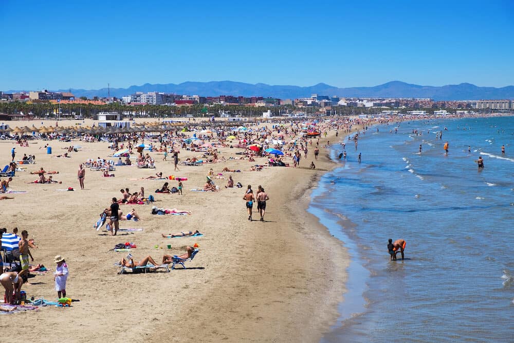 VALENCIA, SPAIN - Sunbathers at El Cabanyal and La Malvarrosa beaches in Valencia, Spain. These are the main beaches in the capital of the Valencian Community