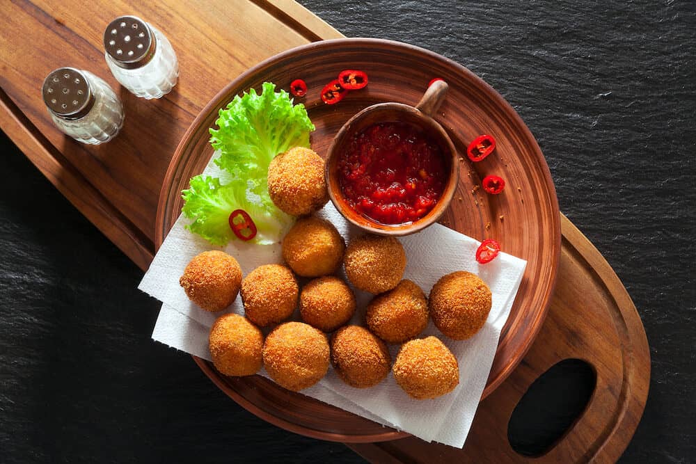 Fried Arancini rice balls . Typical Sicilian street food with spicy sauce