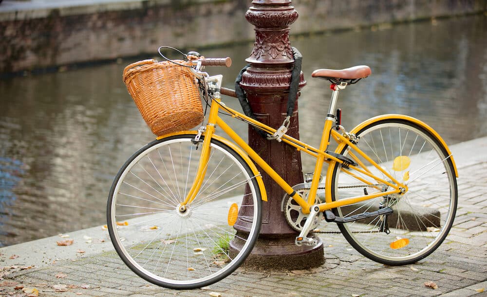 Yellow bike near city street pole. Bruges, Belgium