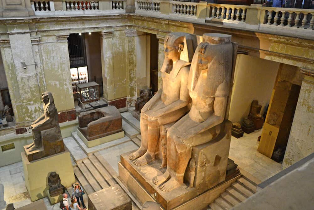 Cairo, Egypt - Large statues of the Egyptian pharaoh and his wife in the hall of the Egyptian museum in Cairo. View from above.