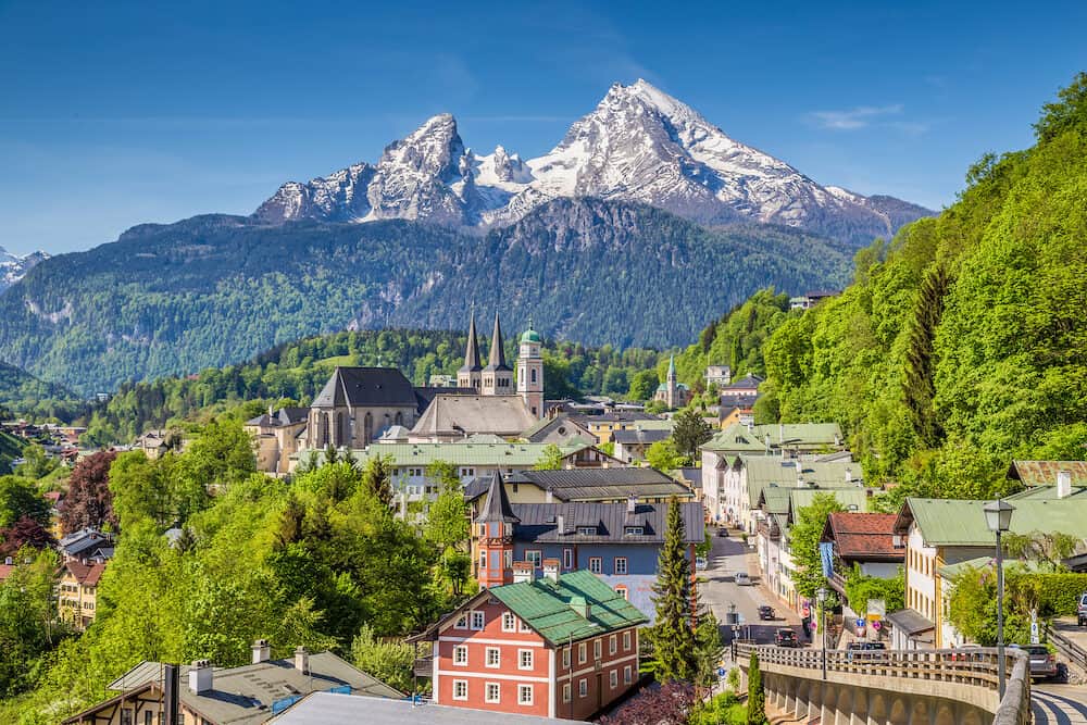 Historic town of Berchtesgaden with famous Watzmann mountain in the background on a sunny day with blue sky and clouds in springtime, Nationalpark Berchtesgadener Land, Upper Bavaria, Germany