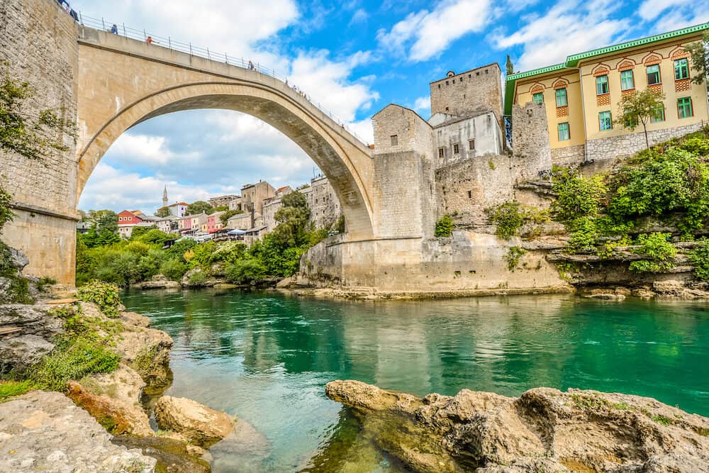 The emerald green waters of the river Neretva flow under the Mostar Bridge in the ancient city of Mostar, Bosnia and Herzegovina