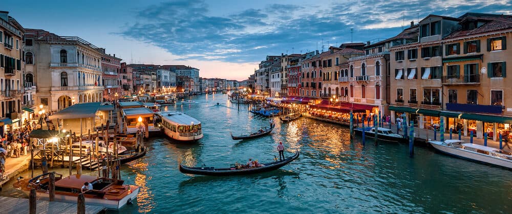 Panorama of Venice at night, Italy. Beautiful cityscape of Venice in evening. Panoramic view of Grand Canal at dusk. It is one of the main travel attractions of Venice. Romantic water trip in Venice.