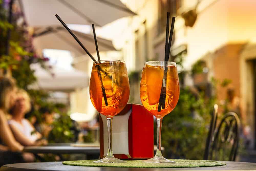 Aperol Spritz Cocktail. Alcoholic beverage based on table with ice cubes and oranges.