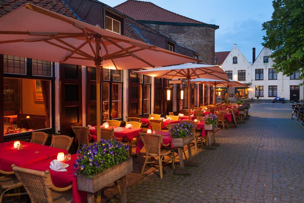 Cafes and restaurants with terraces at nighttime in Bruges, Belgium