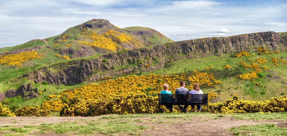 People looking at Arthur's Seat and Salisbury crags - view from Calton hill at Edinburgh, Scotland